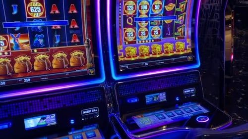 Deretan mesin slot dengan lampu berkilau di sebuah kasino
